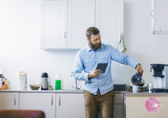 Man pouring coffee in cup at kitchen