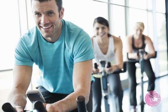 People exercising on stationary bikes in fitness class